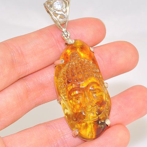 Sterling Silver 35.4-Carats Carved Amber Buddha Face and 0.5-Carats White Topaz Pendant